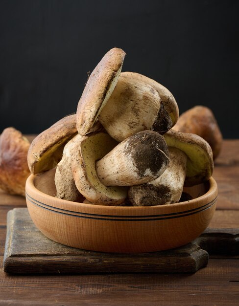 Fresh forest porcini mushrooms in a wooden plate