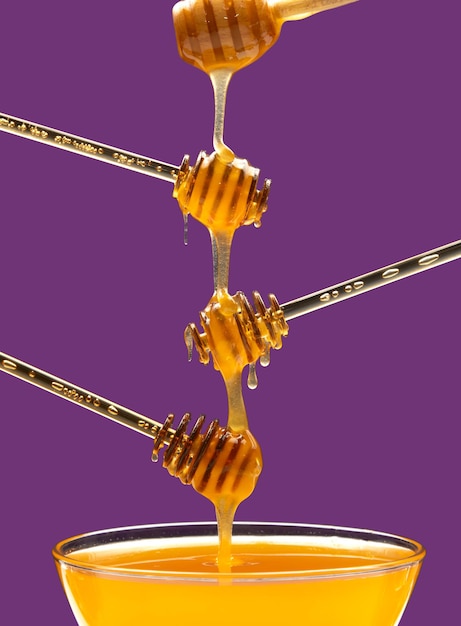 Fresh fragrant honey drips from a spoon into a plate on a colored background organic vitamin nutrition dessert food