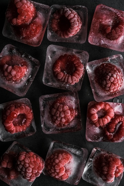 Fresh frozen in ice red raspberry on black background. Macro berries