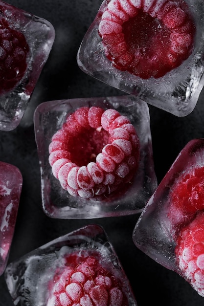 Fresh frozen in ice red raspberry on black background. Macro berries