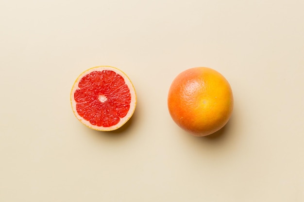 Fresh Fruit grapefruit with Juicy grapefruit slices on colored background Top view Copy Space creative summer concept Half of citrus in minimal flat lay with copy space