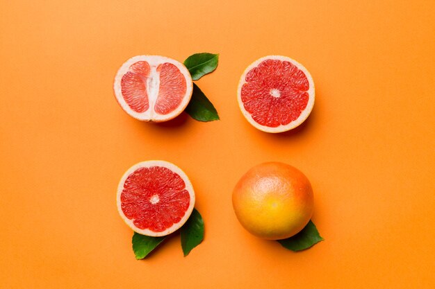 Fresh Fruit grapefruit with Juicy grapefruit slices on colored background Top view Copy Space creative summer concept Half of citrus in minimal flat lay with copy space