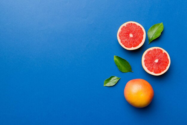 Fresh Fruit grapefruit with Juicy grapefruit slices on colored background Top view Copy Space creative summer concept Half of citrus in minimal flat lay with copy space