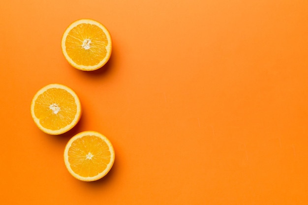 Fresh Fruit orange slices on colored background Top view Copy Space creative summer concept Half of citrus in minimal flat lay with copy space