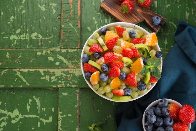 Fresh fruit salad, blueberries, strawberries, grapes, kiwi, orange. Top view