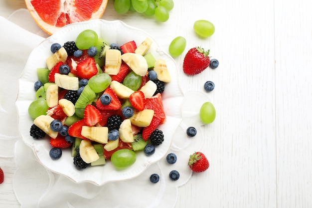 Fresh fruit salad on white wooden table