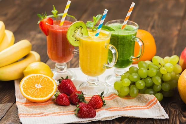 Fresh fruit and vegetable smoothie on kitchen table in glass