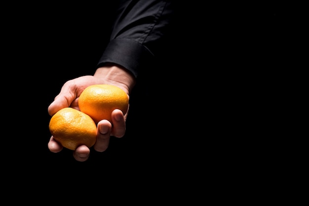 Fresh fruits. Close up of young mans hands holding tangerines