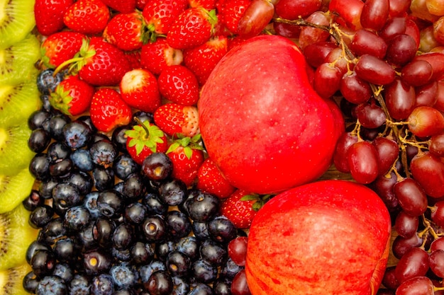 Fresh fruits concept Healthy fruits consist of grapes apple orange and berry as background