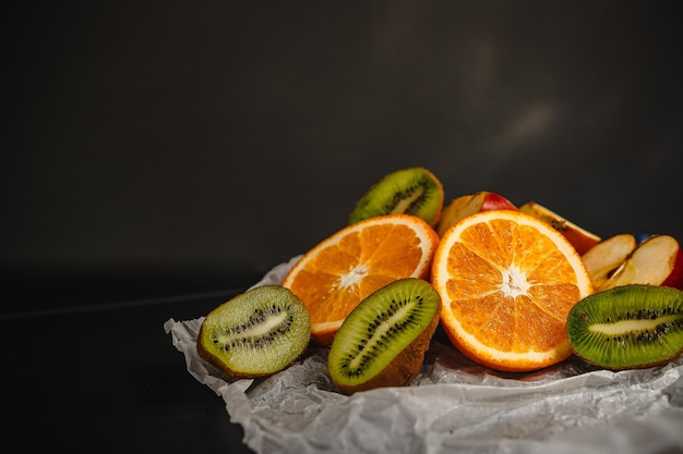 Fresh fruits on a dark background Orange and kiwi in a cut isolated on a black background Copy space high resolution product