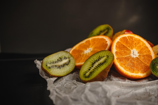 Fresh fruits on a dark background Orange and kiwi in a cut isolated on a black background Copy space high resolution product