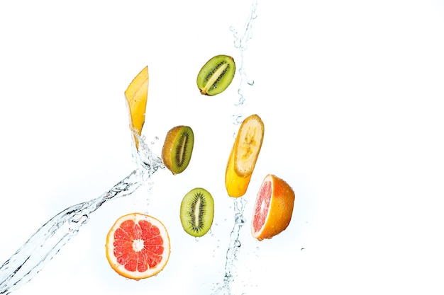 Photo the fresh fruits falling with water splash, isolated on white background