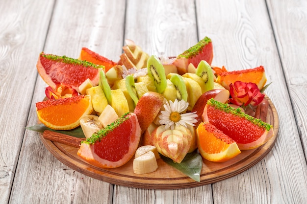 Fresh fruits in plate on wooden table