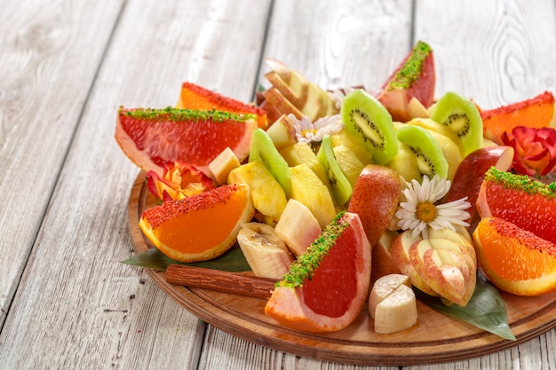 Fresh fruits in plate on wooden table