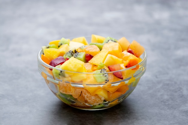 Fresh fruits salad - mango, citrus, kiwi fruit, plum and persimmon. Healthy food.