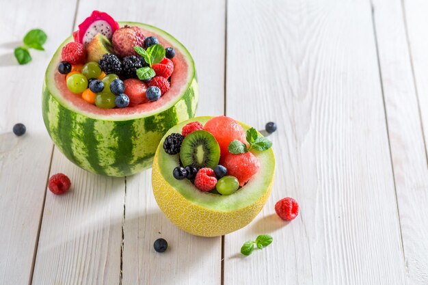 Fresh fruits salad in watermelon in summer kitchen