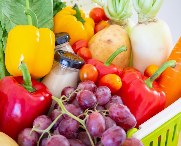 Fresh fruits and vegetables in green shopping basket