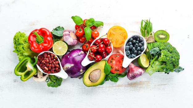 Fresh fruits and vegetables on a white wooden background Top view Free space for your text