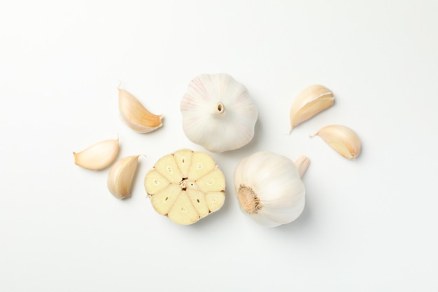 Fresh garlic bulbs, slices on white background, top view. Space for text