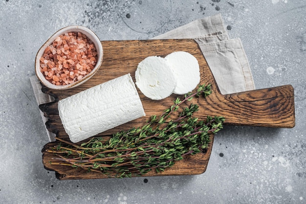 Fresh goat soft cheese with thyme Gray background Top view