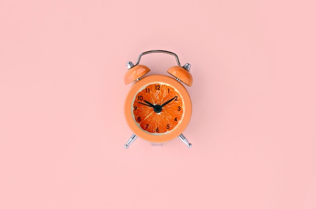 Fresh grapefruit slice in small orange alarm clock