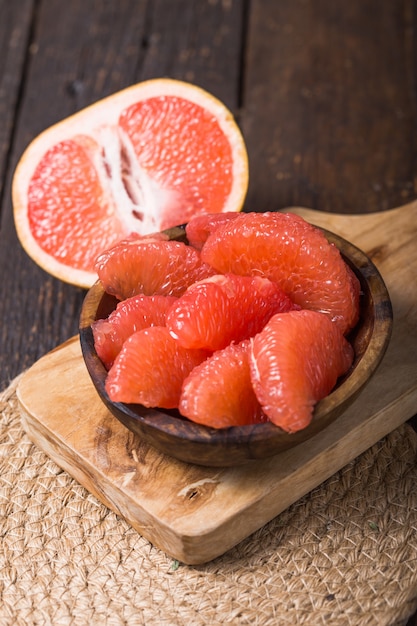 Fresh grapefruit slices in a wooden bowl, healthy snack