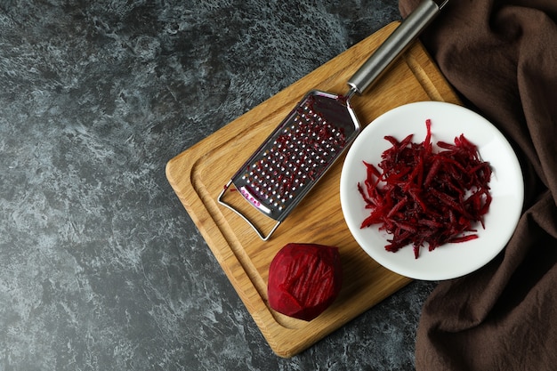 Fresh grated beets on black smokey table