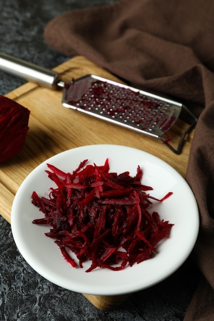 Fresh grated beets on black smokey table