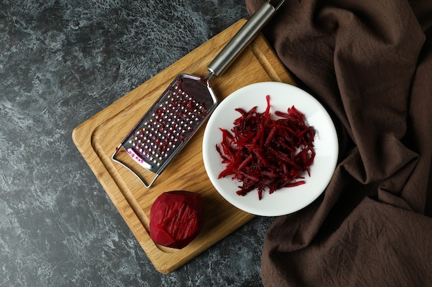 Fresh grated beets on black smokey table