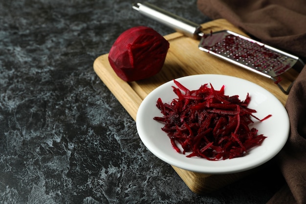 Fresh grated beets on black smokey table