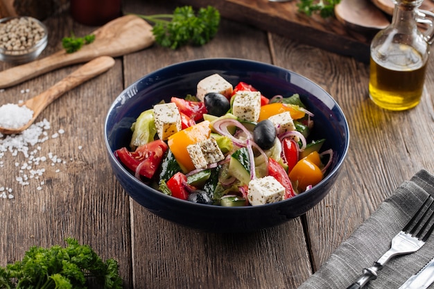 Fresh greek salad in a black bowl