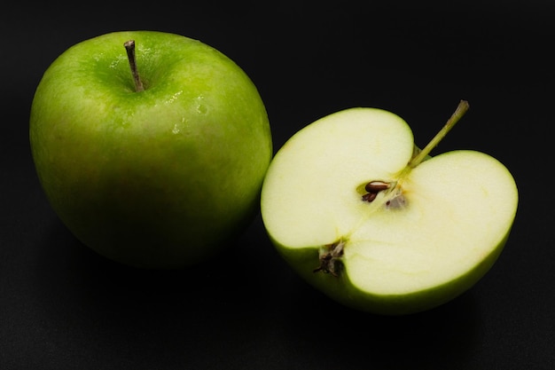 Fresh green apple and sliced isolated on black background art abstract concept