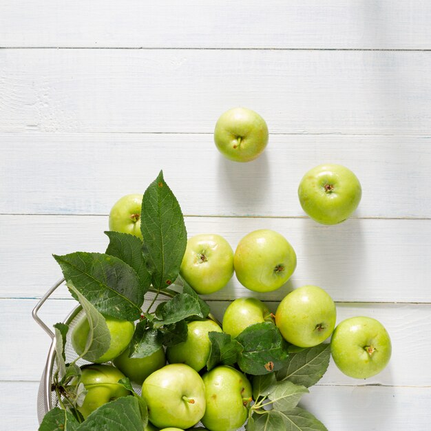 Fresh green apples in sieve top view