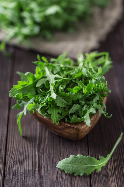 Fresh green arugula in bowl on table. Arugula for salad