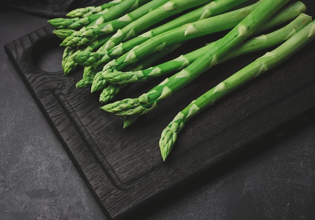 Fresh green asparagus sprouts on a wooden background View from above