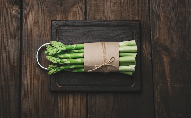 Fresh green asparagus sprouts on a wooden background View from above