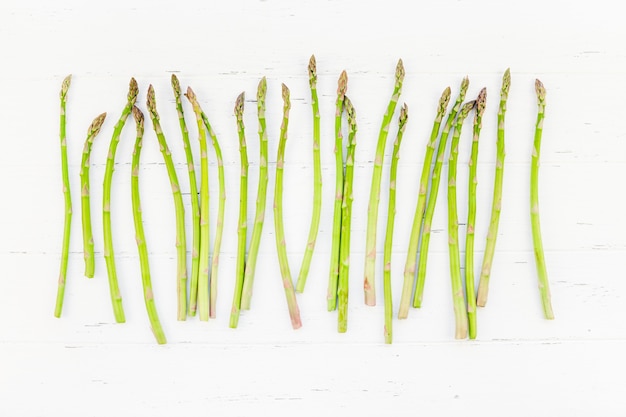 Fresh green asparagus on white wooden surface