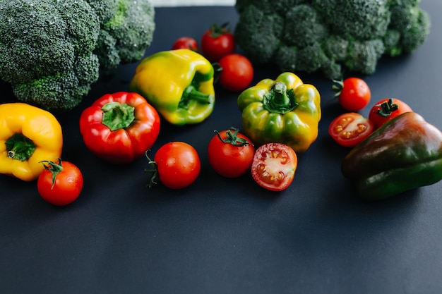 Fresh green broccoli and other vegetables, drops of water on broccoli. Gray background. High quality photo