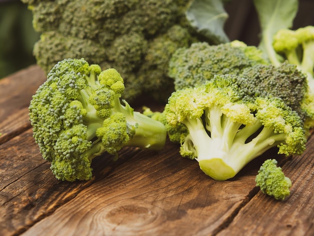 Fresh green broccoli on a wooden cutting board with a knife Broccoli cabbage leaves