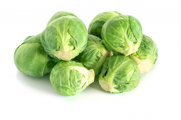 The Fresh green brussel sprouts vegetable on white surface