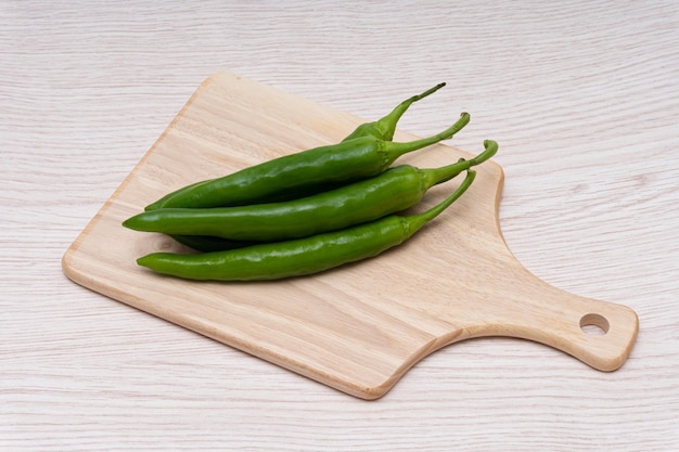 Fresh green chillies plated on a white background