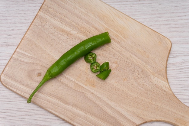 Fresh green chillies plated on a white background