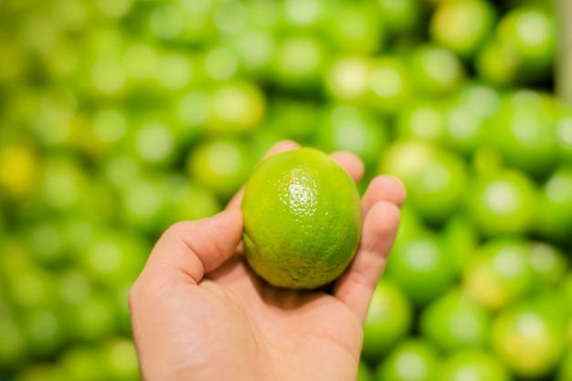 Fresh green lemons in supermarket