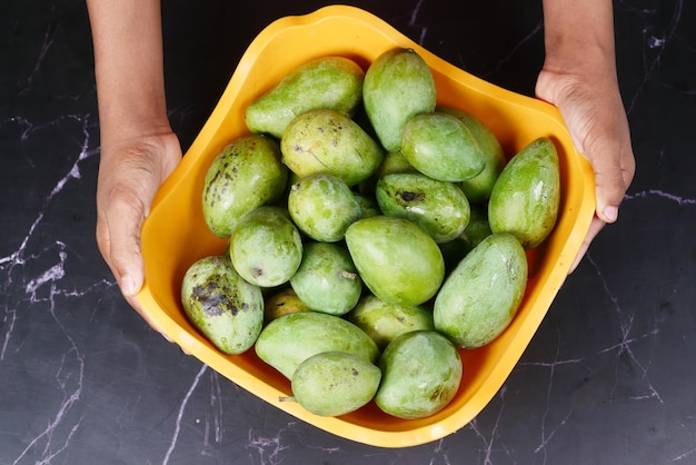 Fresh green mango in a bowl on table