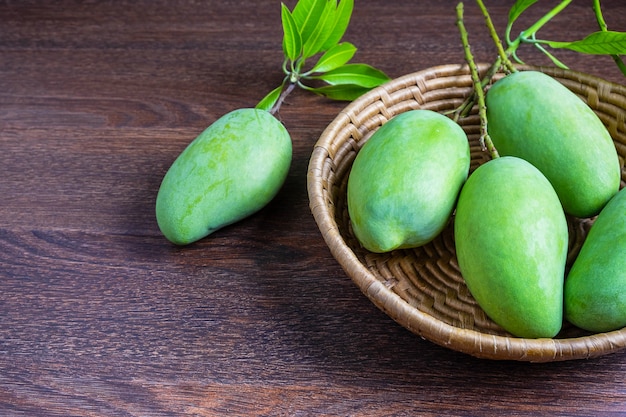 Fresh green mango fruit in a wooden basket