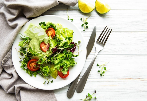 Fresh green mixed  salad bowl with tomatoes and micro greens