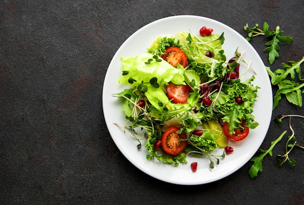 Fresh green mixed  salad bowl with tomatoes and microgreens