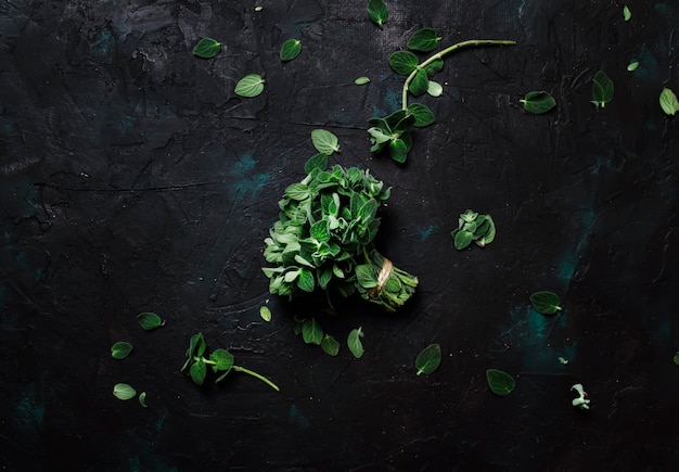 Fresh green oregano or Origanum vulgare in a beam brown background top view