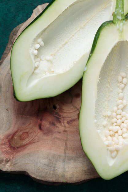 Fresh green papaya splitted into two pieces and arranged on a wooden piece