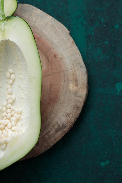 Fresh green papaya splitted into two pieces and arranged on a wooden piece